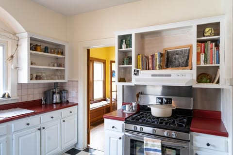 Kitchen with small appliances, handmade  dinnerware, & a small cookbook library