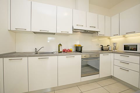 The fully equipped kitchen  with dishwasher, oven, cooker hob and Microwave