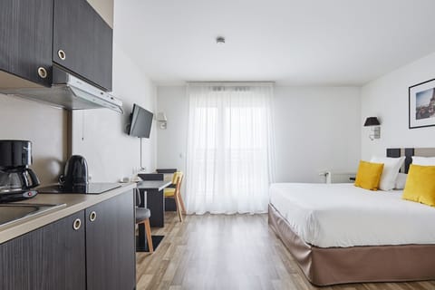 Experience comfort in the cozy living/sleeping area featuring a flexible double or twin bed setup, complemented by a well-equipped kitchenette and a bright ambiance.