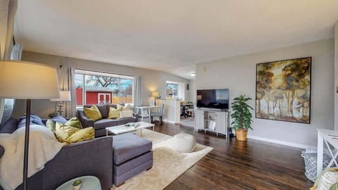 Stylish and cozy living area with a plush sectional, warm lighting, and modern decor. The open layout connects seamlessly to the kitchen, creating a welcoming space for relaxation and entertainment.