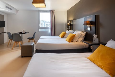 The spacious Superior Studio showcases a modern aesthetic with two cozy beds adorned with vibrant yellow cushions, perfect for accommodating up to three guests.