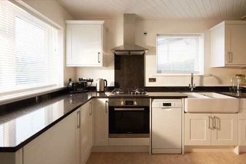 Modern Kitchen featuring granite worktops, natural stone floors & Belfast sink.