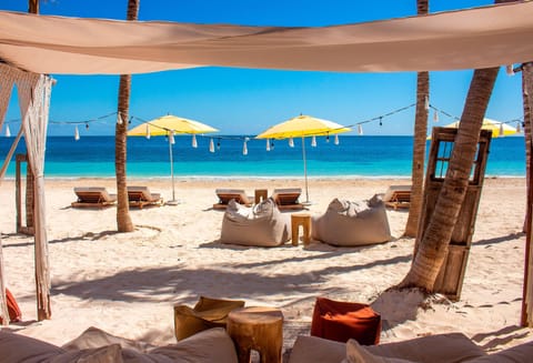 On the beach, white sand, beach cabanas, sun loungers