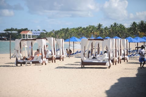 On the beach, white sand, sun loungers, beach umbrellas