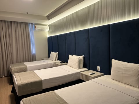 Deluxe Triple Room | Minibar, in-room safe, desk, laptop workspace