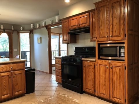 Another angle of kitchen, looking toward dining areas  and deck outside