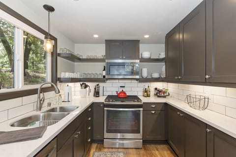 Upgraded appliances and self-closing cabinets, fully stocked kitchen with spices