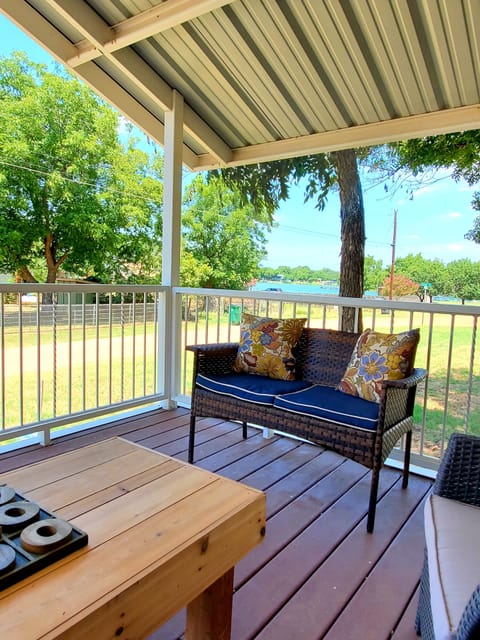 Large covered front porch with a view of the lake across the street.