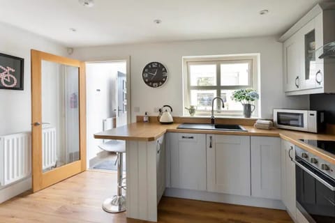 Fully fitted kitchen with breakfast bar and door/window to entrance porch.