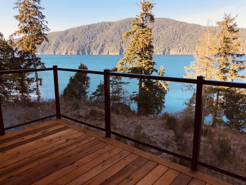 The balcony overlooks the inlet and the mountains beyond