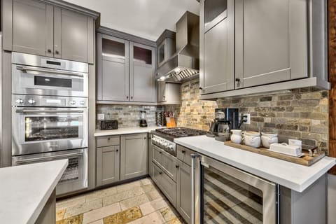 The kitchen is fully stocked with small appliances and dishware