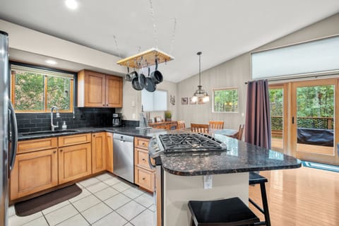Modern full kitchen with stainless steel appliances and warm wood cabinetry, complemented by a spacious breakfast bar—ideal for casual dining or entertaining after a day on the mountain.