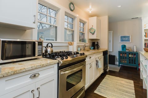 Cook at the stove while watching the kids play in the fenced backyard.