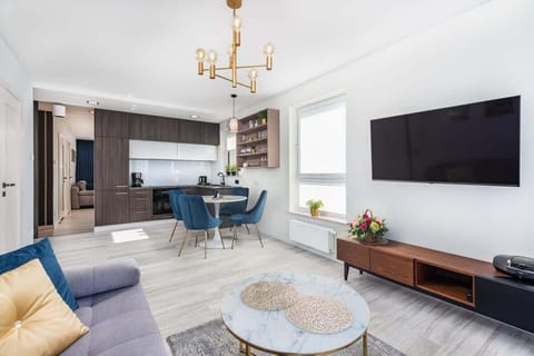 The stylish living room space combined with the kitchenette creates a cohesive whole. 