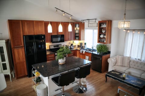 Kitchen with huge granite-top island, leather bar chairs, full set of appliances
