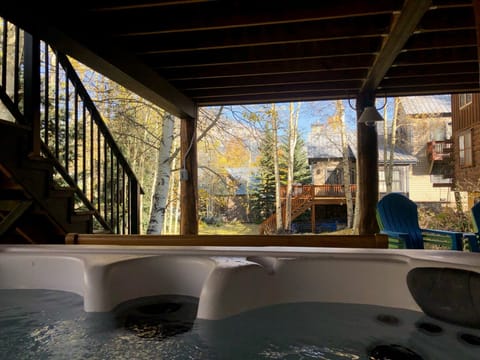 Covered outdoor living space with hot tub view of Mt. Crested Butte