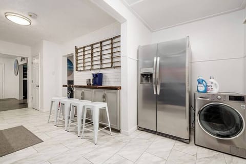 Kitchen bar, large fridge and washer/dryer combo.