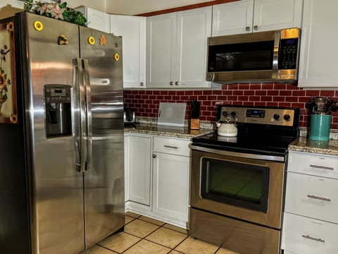 Fullsize side-by-side refrigerator.  Electric Stove/oven with overhead microwave