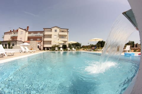 Seasonal outdoor pool, a waterfall pool, pool umbrellas, sun loungers