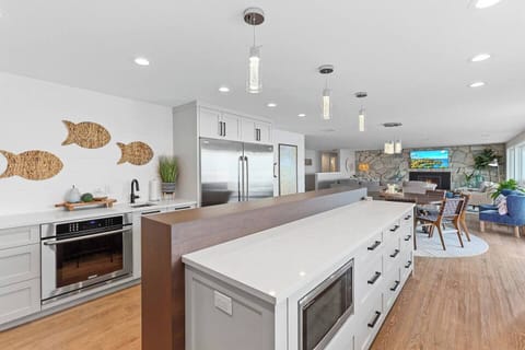 A wide angle view from the kitchen to the dining table and living room