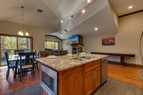 - Granite island with sink and seating
- Dining area with sliding door to deck
- Spacious living with fireplace views