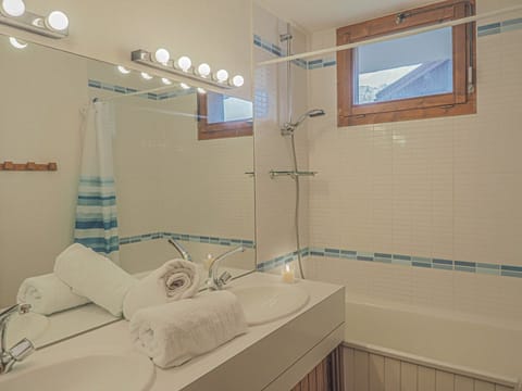 Family bathroom with double sinks and bath with shower over