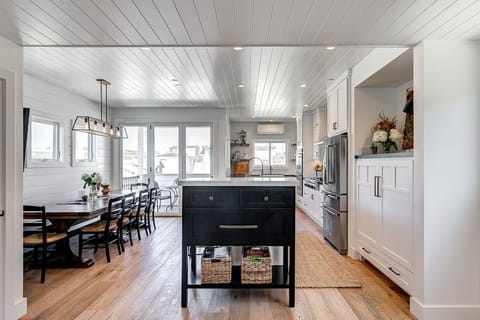 Enjoy the second level's open floor plan, with kitchen, dining area, and porch flowing seamlessly together, as well as a cozy living area (behind camera).