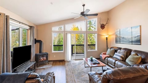 Cozy living room with gas fireplace, HDTV with streaming capabilities, vaulted ceilings, walk out balcony with alpine views.