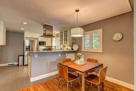 Stylish dining at custom walnut table complete with four chairs, offering a chic dining experience.