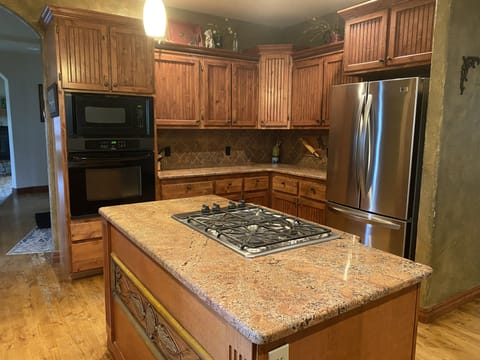 Large kitchen with refrigerator, oven/microwave, and gas cooktop