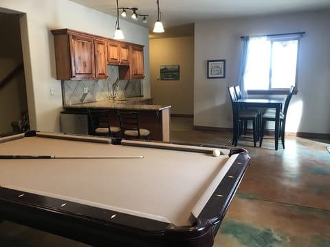 Wet bar, mini fridge, and eating area in bright walkout level