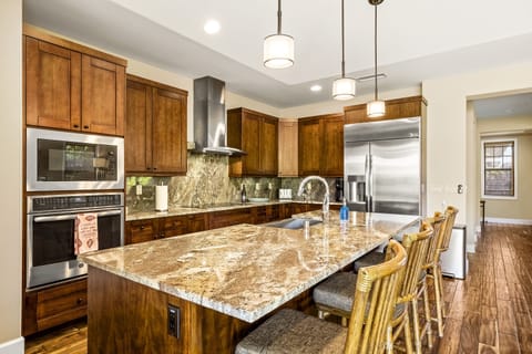 Kitchen of this Holua Kai at Keauhou rental, complete with in-island sink, bar seating, and stainless steel appliances.