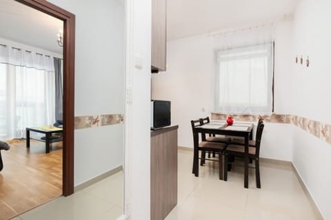 A kitchen with light wooden cabinets, a built-in oven, and a spacious counter. It is clean and practical.