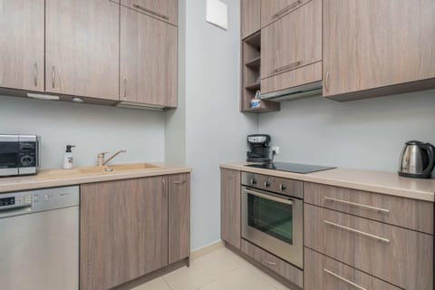 A kitchen with light wooden cabinets, a built-in oven, and a spacious counter. It is clean and practical.