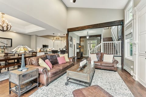 Living room (main floor): Gas fireplace, flat-screen TV, built-ins, armchair, coffee table, deck access with gas grill