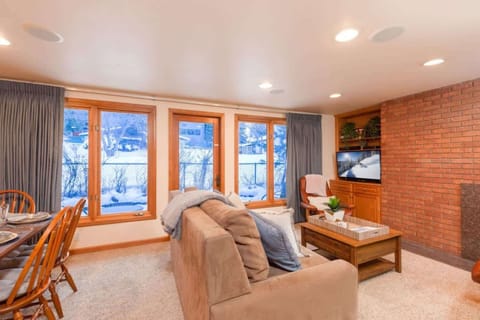 Bright and spacious living room with fireplace and large floor-to-ceiling windows