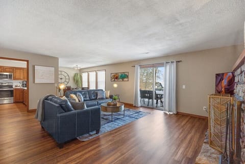 Sliding door leads to back patio with table and chairs along with BBQ Grill.