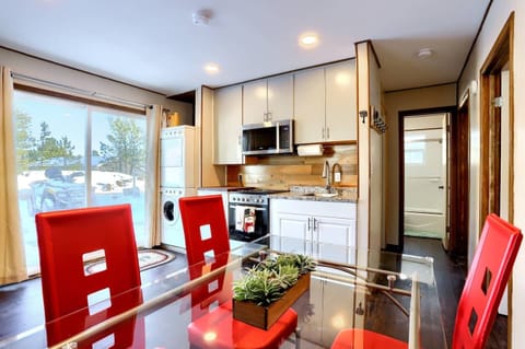 - Delicious meals in this sleek kitchen with granite counters & full appliances
- Dine in style at a modern glass table surrounded by bold red chairs for a pop of flair
- Natural light floods in through patio doors leading to scenic outdoor moments