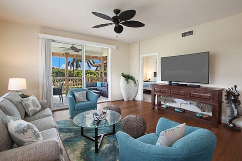 Bright and breezy living area with modern Hawaiian décor, plush seating, and flat-screen smart TV — the perfect spot to unwind after a day on the golf course.