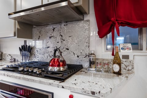 A kitchen accented with a vibrant red kettle and a sleek knife set, combining functionality with a touch of bold color.