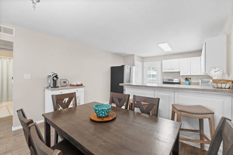 Spacious dining area with 6 seats and 2 additional spots at the kitchen counter for shared meals.