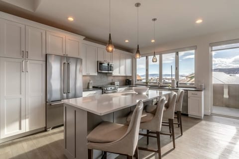 The open kitchen has modern stainless appliances and seating for four at the breakfast bar