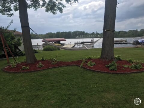 Back yard with sandy beach/swim area, and hammock.