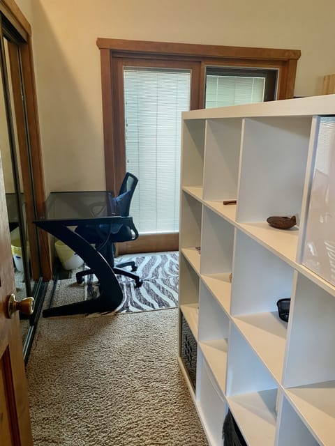 View from the hallway door of the 2nd bedroom upstairs with a king bed & slider