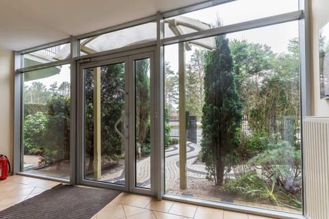 Outdoor garden area with green grass and trees, offering a peaceful environment for relaxation.