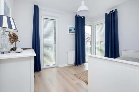 : Another view of a bedroom featuring white furniture and minimalist decor.