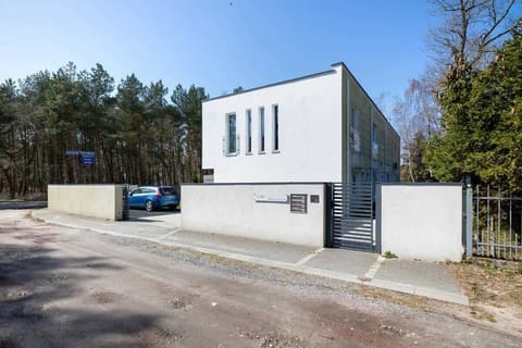 A sleek, modern building with a minimalist design, surrounded by trees.