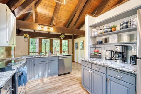 Whether you’re whipping up a meal or enjoying a coffee, this kitchen is the heart of the cabin, featuring modern appliances like a new electric stove, dishwasher, and refrigerator, along with updated cabinet colors, gorgeous new granite countertops, and a stylish picket tile backsplash.