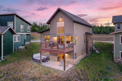 - Sunset view of mountain cabin exterior with tall windows glowing warmly - Private deck and hot tub add charm for mountain stays - Scenic rental home perfect for peaceful Colorado getaway