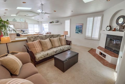 Upstairs living room with comfy couches, queen sofa bed, TV, and ceiling fan